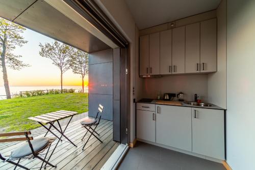 a kitchen with a balcony with a table and chairs at Lauču Akmens in Skulte