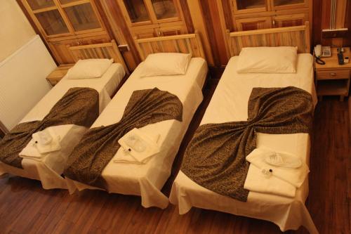 three beds in a room with wooden floors at Duran Aga Konagi in Şahinbey
