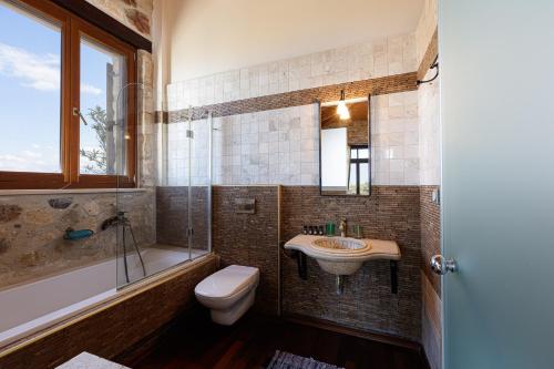 een badkamer met een wastafel, een toilet en een bad bij Villa Candice in Maroulás