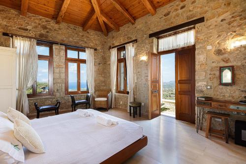 een slaapkamer met een groot bed in een kamer met ramen bij Villa Candice in Maroulás