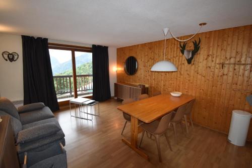 un salon avec une table et un canapé dans l'établissement VAUJANYLOCATIONS - Cochette 1 Apt 5, à Vaujany