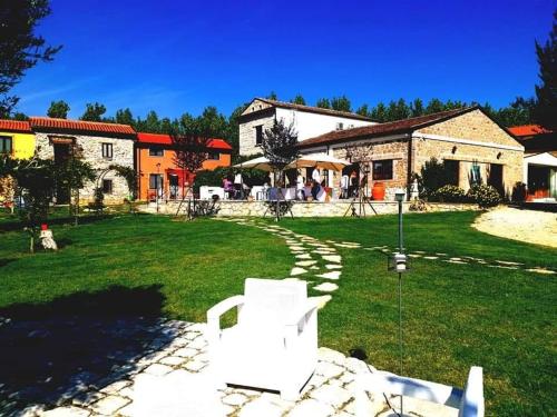 a yard with a white chair in front of a building at AGRITURISMO iL PIOPPETO in Cassino