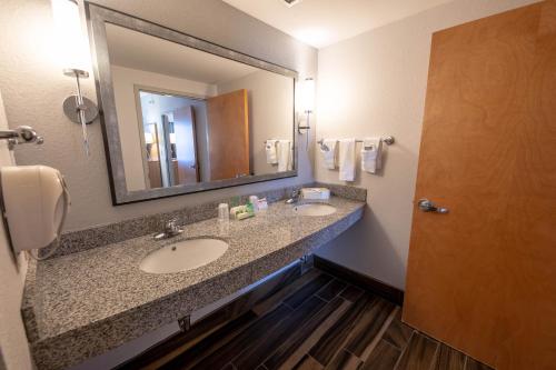a bathroom with two sinks and a large mirror at Holiday Inn Manahawkin/Long Beach Island by IHG in Manahawkin