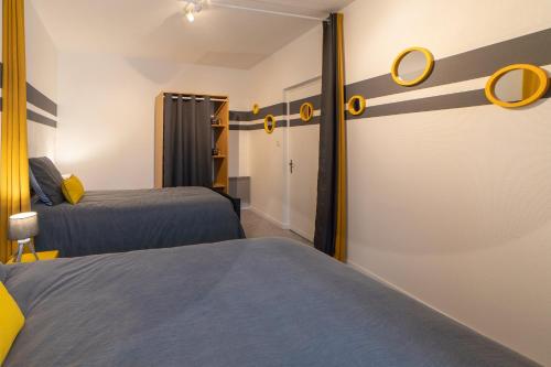 a room with two beds and a closet at Le Félix Grat - LAVALOC in Laval