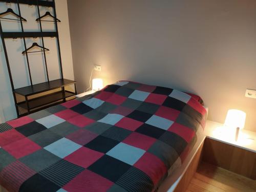 a bedroom with a bed with a checkered blanket at Imagine in Houthalen-Helchteren