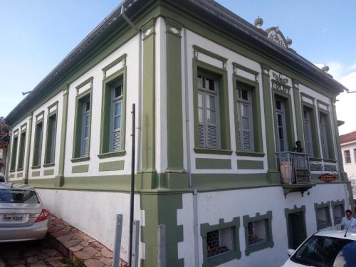 een groen en wit gebouw met een balkon bij Pousada Gameleira in Diamantina