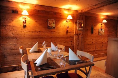 uma sala de jantar em madeira com uma mesa com planos de papel em Hotel De Ville em Rossinière