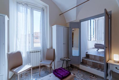 una camera con un letto, due sedie e uno specchio di La Casa di Max a Sanremo