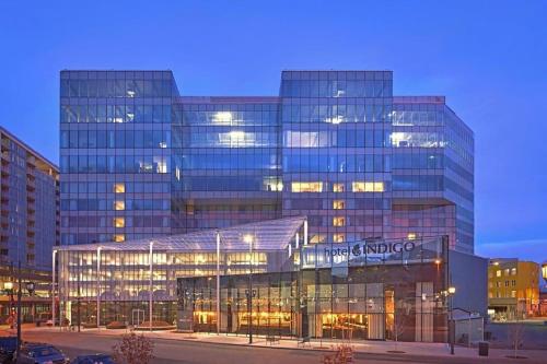 un gran edificio de cristal en una ciudad por la noche en Hotel Indigo Denver Downtown - Union Station, an IHG Hotel, en Denver