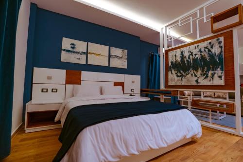 ein Schlafzimmer mit einem großen Bett und einer blauen Wand in der Unterkunft Travelholic Residence New Cairo in Kairo