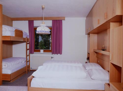 a bedroom with two bunk beds and a window at Appartement Wasserer in San Giovanni in Val Aurina
