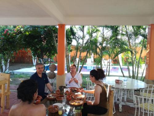 un grupo de personas sentadas alrededor de una mesa en Casa de Playa Coco'z, en Coyuca de Benítez