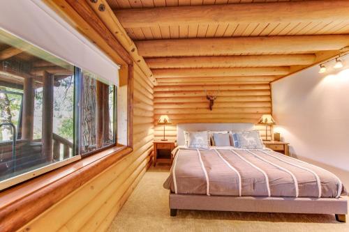 a bedroom in a log cabin with a bed and a window at Pine Cone Haven in Idyllwild