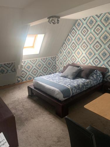 a bedroom with a bed with a blue wall at Chambres d'hôtes de l'Eglise in Sainte-Mère-Église