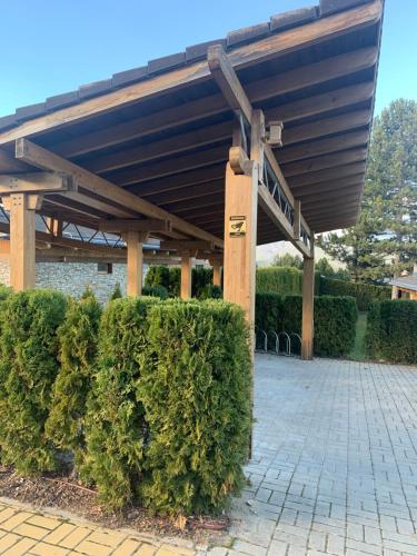 a building with awning over some bushes at Pirin Golf Villa Emila in Bansko