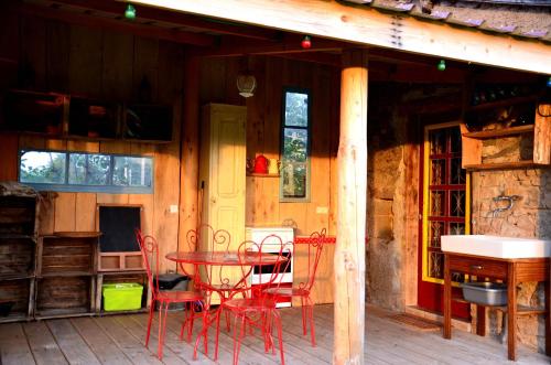 una mesa y sillas en el porche de una cabaña en La Roulotte de la Fay, en Dompierre-les-Ormes