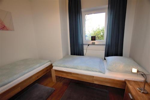 two beds in a small room with a window at Ferienwohnung Heideblick in Volkesfeld