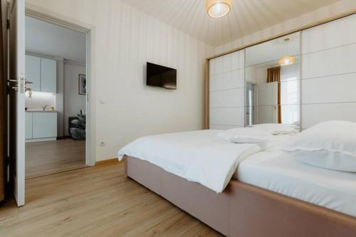 una camera da letto con un grande letto bianco e uno specchio di Oasis Residence a Baia Mare