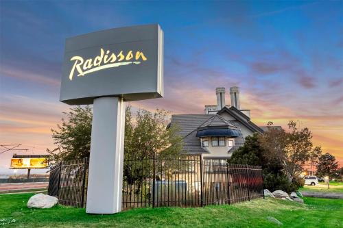 a sign in front of a house with a building at Radisson Hotel Salt Lake City Airport in Salt Lake City