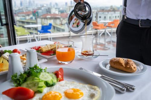 eine Person, die ein Glas Wein über einen Teller mit Lebensmitteln schüttet in der Unterkunft Point Hotel Taksim in Istanbul