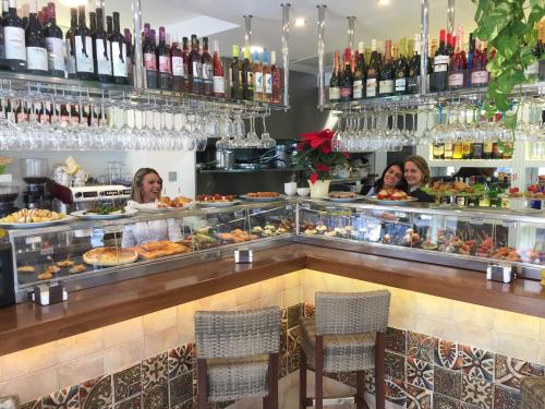 a group of people sitting at a counter with food at Sea to Sky Suites - Mijas Pueblo in Mijas