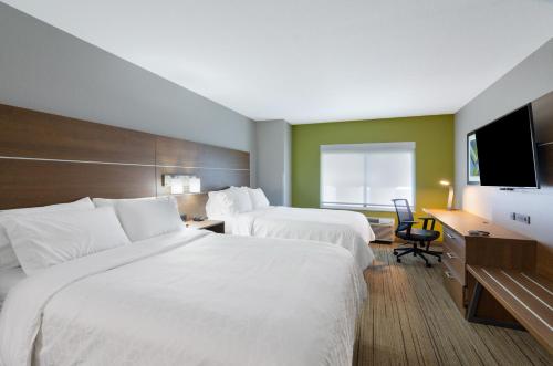 a hotel room with two beds and a flat screen tv at Holiday Inn Express Hotel & Suites Weston by IHG in Weston