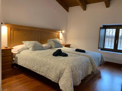 a bedroom with a bed with a pair of shoes on it at Atico Jaca Centro in Jaca