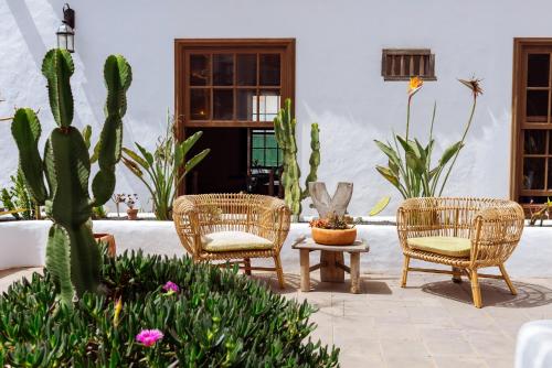 a patio with three chairs and a table and cactus at Hotel Boutique Palacio Ico in Teguise