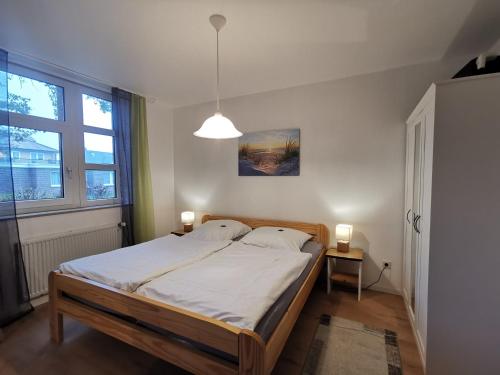 1 dormitorio con 1 cama grande con sábanas blancas en Meeresbrise, en Horumersiel