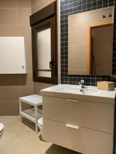 a bathroom with a sink and a mirror and a toilet at Atico Jaca Centro in Jaca