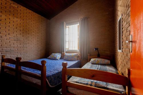 a bedroom with two beds and a window at Casa c/ churrasqueira próximo à praia em Ubatuba in Ubatuba