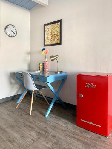 a blue desk with a chair and a red refrigerator at Hotel McCoy - Art, Coffee, Beer, Wine in Tucson