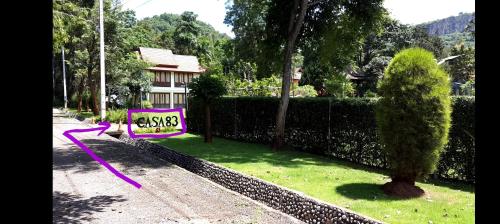 a purple sign sitting in the grass next to a fence at Casa Khaoyai Bed&Breakfast in Mu Si