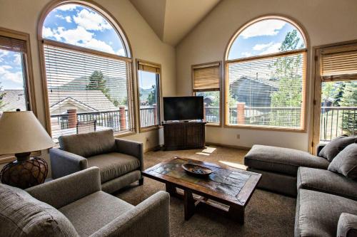 a living room with couches and a tv and windows at The Stanley Hotel in Estes Park