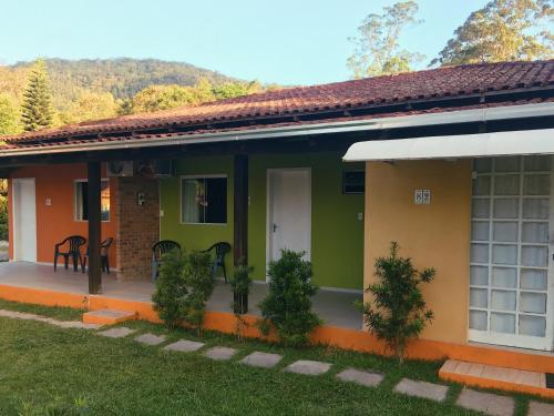una pequeña casa verde y amarilla en Refúgio do Bosque, en Penha