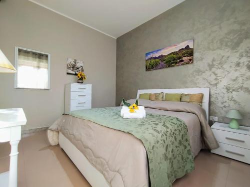 Un dormitorio con una cama con una flor. en Villa da giusi, en Torre dell'Orso