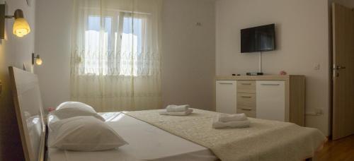 a bedroom with a bed and a dresser and a television at App Krase in Pula