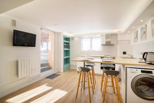 une cuisine avec un évier et un comptoir avec des tabourets dans l'établissement Central & Calme, Design & Zen, Netflix gratuit, à Toulouse