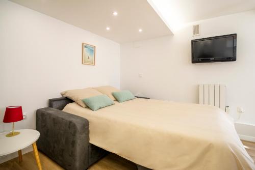 - une chambre avec un grand lit et une télévision murale dans l'établissement Central & Calme, Design & Zen, Netflix gratuit, à Toulouse