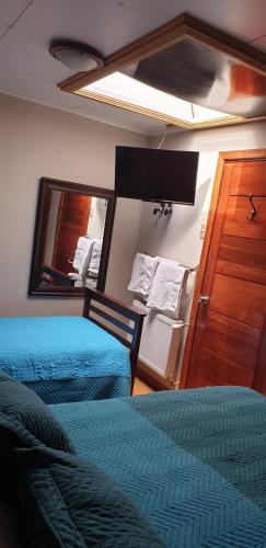 a bedroom with two beds and a mirror at La Casa Guesthouse in Punta Arenas