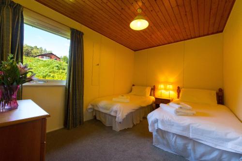 a room with two beds and a window with a window at The Kestrel in Crianlarich