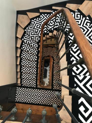 a wooden spiral staircase with a black and white pattern at Maison Caju - La Rochelle in La Rochelle