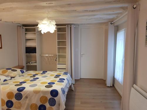 - une chambre avec un lit doté d'une couverture en point de polka dans l'établissement Au coin du Quai entre Mer et Port de plaisance, à Dieppe