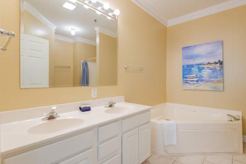 a bathroom with two sinks and a tub and a mirror at 2B Pavilion Watch in Folly Beach