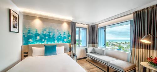 a hotel room with a bed and a window at Tanoa Plaza Hotel in Suva