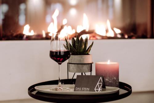 a table with a glass of wine and a candle at DAS STEIN in Amerang