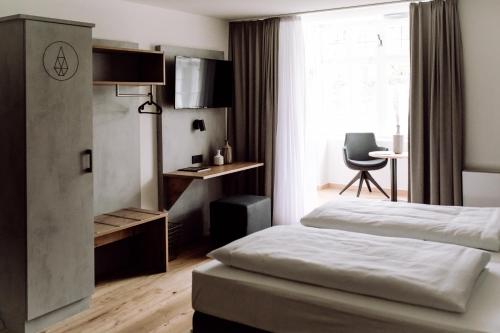 a bedroom with a bed and a desk and a window at DAS STEIN in Amerang