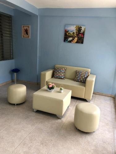 ein Wohnzimmer mit einem Sofa und 2 Ottomanen in der Unterkunft económico Master in Santiago de los Caballeros