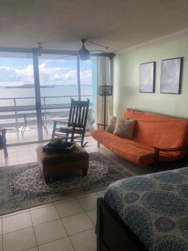 a bedroom with a bed and a couch and a chair at Marina Lanais Condominio in Las Croabas