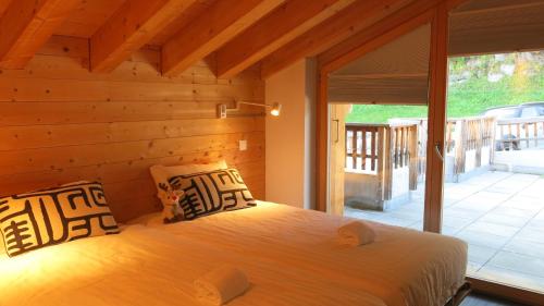 een slaapkamer met een bed met een houten muur bij Ski Paradise MOUNTAIN & LUXE apartments in Veysonnaz